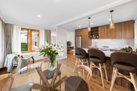 Fully equipped modern kitchen with bar seating (for 3) and dining table (seats 4).