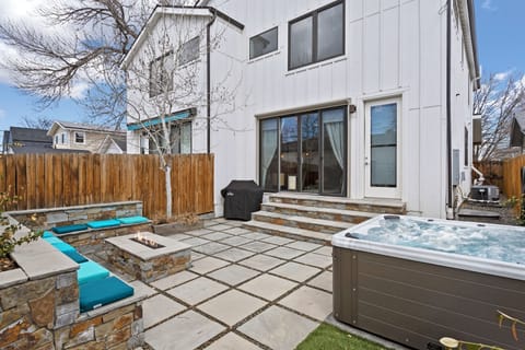 Soak away stress in your private hot tub while the fire pit crackles nearby, creating perfect evenings under the stars in this stylish backyard retreat.