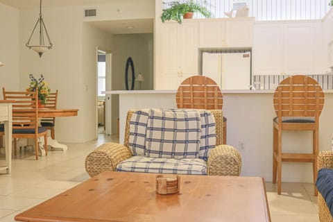 Relax in your bright, airy living space with comfortable wicker seating and an open layout that flows seamlessly into the kitchen.