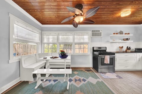 Sunlit breakfast nook with wraparound windows and cozy seating.