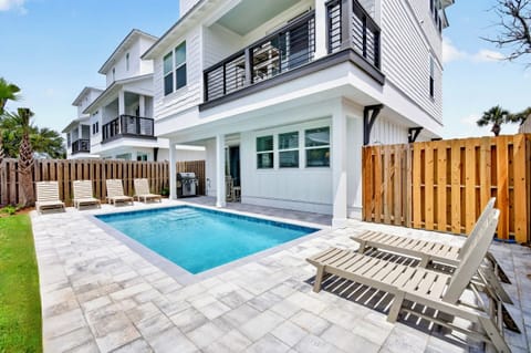 Oceans East—your perfect group getaway that SLEEPS 22! Just steps from the beach, this stunning retreat includes a FREE golf cart. Unwind in the backyard oasis with a HEATED pool, outdoor kitchen, and lounge seating.