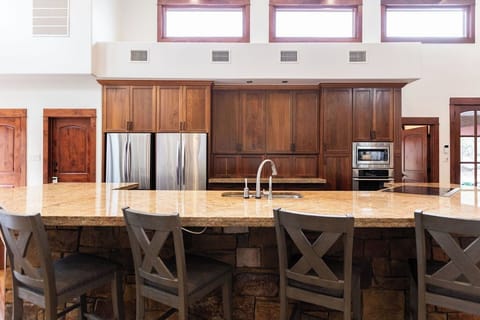 Your gourmet kitchen features rich wood cabinetry, gleaming countertops, and stainless steel appliances - perfect for creating memorable meals during your stay.