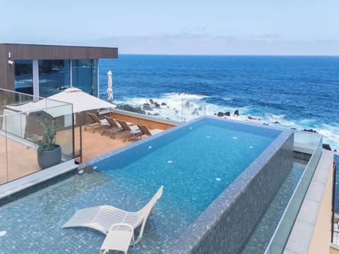 Dive into oceanfront infinity bliss with sun loungers.