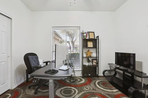 Separate private office, fully equipped with an adjustable desk, desk chair, monitor, printer, shredder, and its own TV