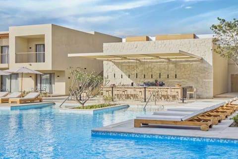 Lounge poolside and sip cocktails at the sunlit swim-up bar