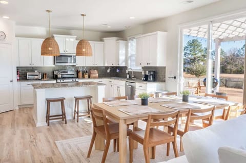 Spacious kitchen with island seating and dining table — perfect for meals and gatherings.