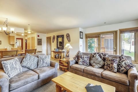 Settle into plush leather sofas surrounded by mountain-themed décor and natural light streaming through patio doors to your outdoor space.