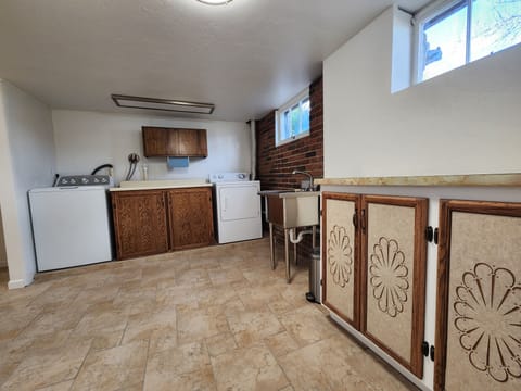 Laundry room with washer/dryer, deep sink, iron & ironing board, clothes steamer