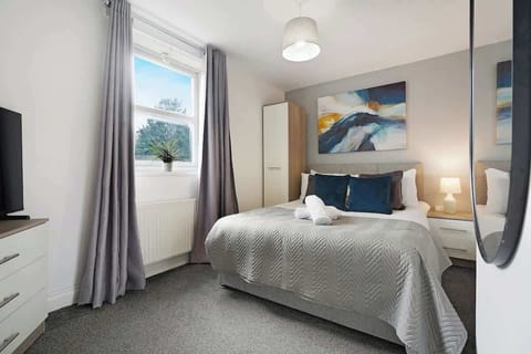 Bedroom 1 is furnished with a double bed, a TV, and storage space.