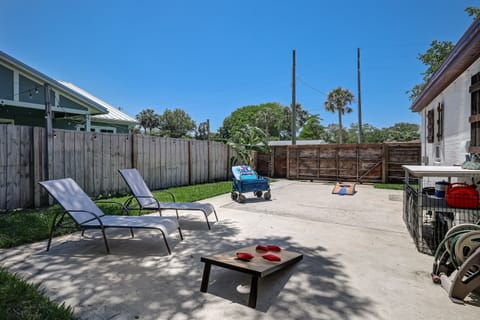 Sunny backyard with lounge chairs and yard games for relaxing afternoons.