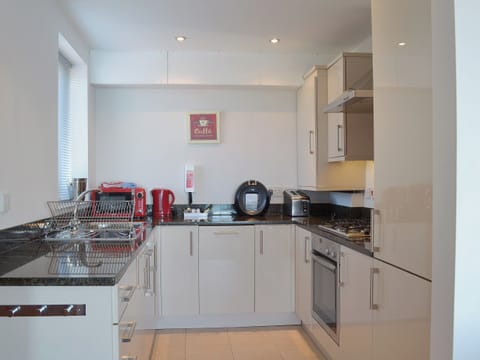 A compact yet well-equipped kitchen area provides all your culinary needs | Apartment 6 - Astor House, Torquay