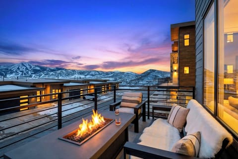 Sip, relax, and take in the sunset—private balcony with a cozy fire table and sweeping mountain views.