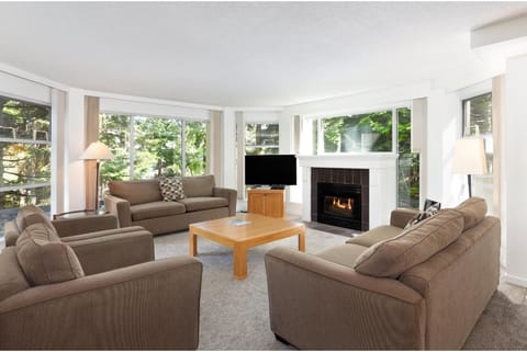 Relax in the sunlit living room beside a glowing fireplace.