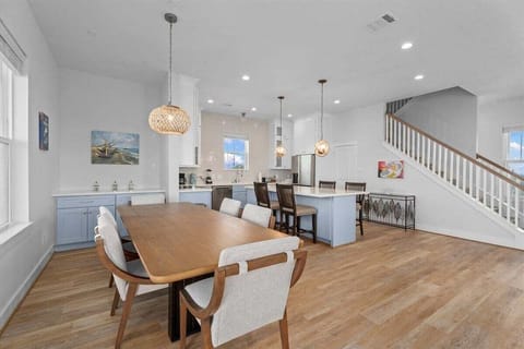 Bright dining area with modern lighting and open layout inside spacious Galveston coastal home.