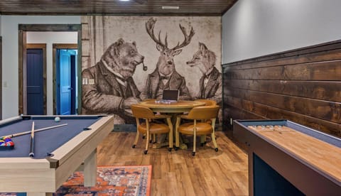 Lower level game room featuring a full size pool table, shuffleboard, and whimsical woodland mural with bear, deer, and fox in suits at Blue Bird three-level cabin in the Smoky Mountains, Tennessee