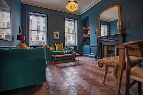 Spacious elegant living room with gorgeous Victorian fireplace, 42 inch TV, glamorous gold fittings, parquet flooring, sash windows and beautiful cornicing.