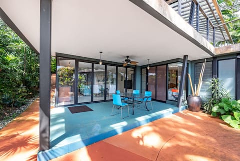 Your modern covered lanai seamlessly blends indoor comfort with tropical tranquility, perfect for dining surrounded by lush greenery.