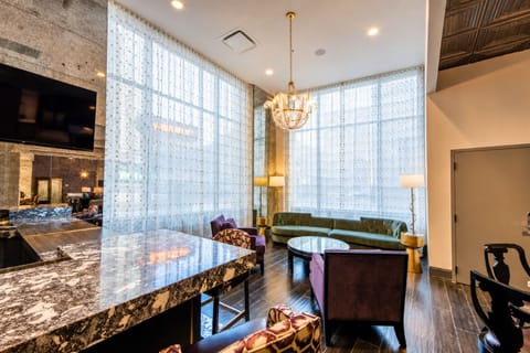 Stretch out on cozy seating beneath warm lighting and curtains.