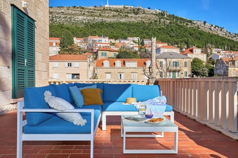 Relax on your private terrace with a glass of wine, enjoying stunning views of the historic cityscape and the lush green hills beyond.