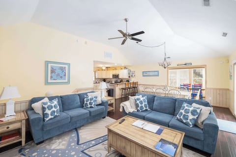 Bright Living Room w/ Blue Sofas, Wooden Coffee Table, Wooden Fireplace, Built-In TV, and Large Arched Window