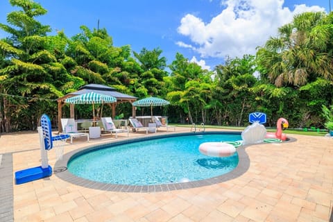 Private resort-style backyard featuring a sparkling pool, hot tub, mini golf, ping pong, and outdoor grill — your own South Tampa oasis for making unforgettable memories