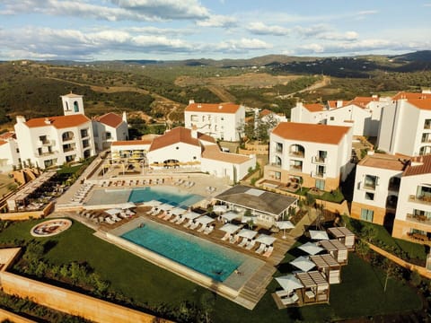 Arrive to a sunlit resort oasis with sweeping hillside views.