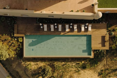 Unwind poolside on sun loungers beside shimmering blue water.