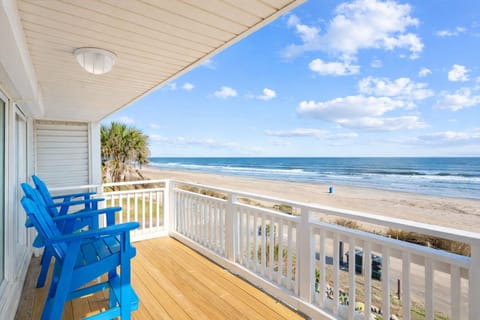 Oceanfront deck with blue Adirondack chairs and panoramic Gulf of Mexico views at Bermuda Beach vacation rental in Galveston.