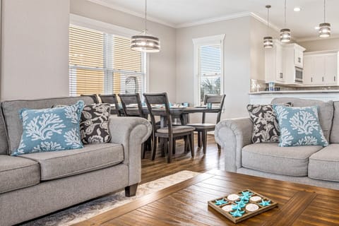 Coastal-inspired living area with gray sofas and open flow.