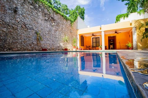 Dive into a sunlit courtyard pool framed by stone walls.
