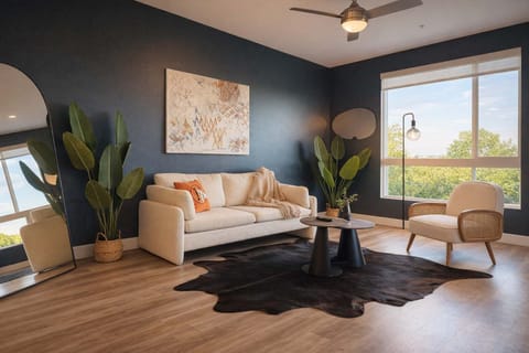 Spacious living room featuring a cozy sofa, a full-size air mattress, and a 65" Smart TV with preloaded access to Netflix, Hulu, and Disney+, all set up for your enjoyment.