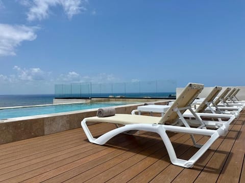 Soak up ocean breezes from your lounger beside infinity waters.