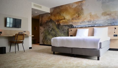 Unwind in a bright king room with dramatic mural backdrop.