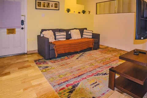 Spacious living room with bohemian touches and wooden floors, ideal for unwinding after exploring the city. Perfect for solo travelers seeking a peaceful corner.