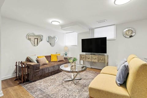 Relax in style in our bright and airy living room featuring comfortable seating, contemporary decor, and a large flat-screen TV in Ottawa.