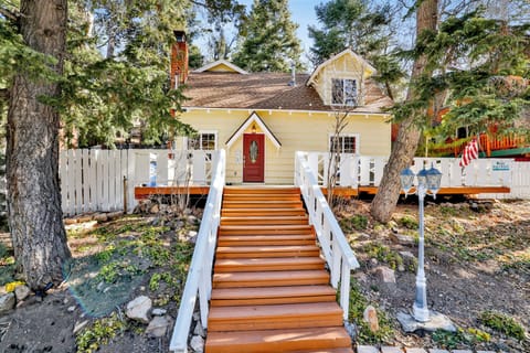 Welcoming cabin entry surrounded by towering pine trees, offering fresh mountain air and a peaceful forest setting—the perfect first impression for your Big Bear Lake getaway.