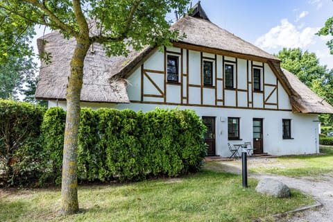 Exterior view of a half-timbered house with a thatched roof