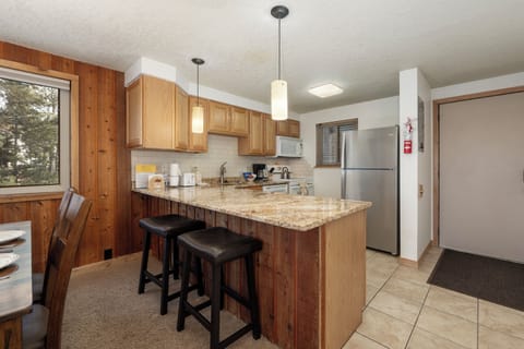 Your fully equipped kitchen features granite counters, stainless steel appliances, and a breakfast bar where you can sip morning coffee.