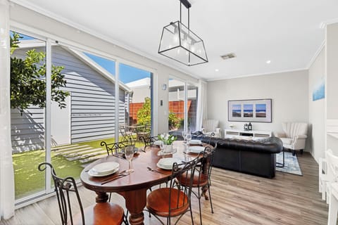 Host unforgettable dinners in this sun-drenched, open-concept space where classic timber furnishings meet contemporary design and sliding glass doors that open right onto the garden.