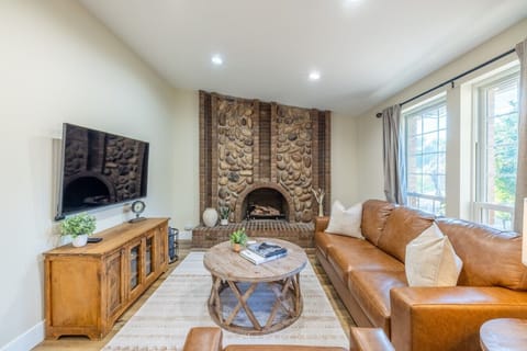 Bright living room with stone fireplace and comfortable seating