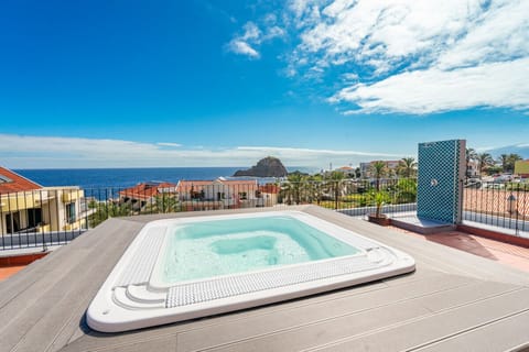 Soak in the rooftop hot tub overlooking sparkling blue water.