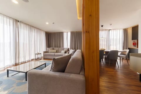 Unwind on plush sofas in a sunlit, open-plan lounge.