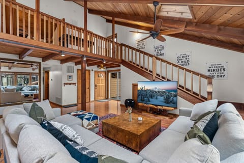 Unwind in your spacious living room where rustic wooden beams meet modern comfort, complete with mountain views on the big screen.