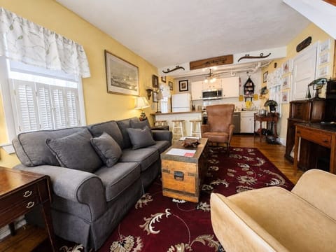 Spacious main living area with comfortable seating, TV and the kitchen just beyond.