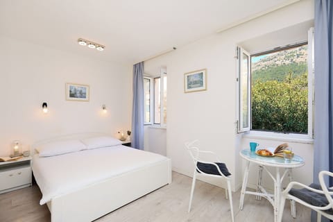 Begin your day with breakfast by the window, enjoying verdant hillside views from this bright and airy heritage studio.