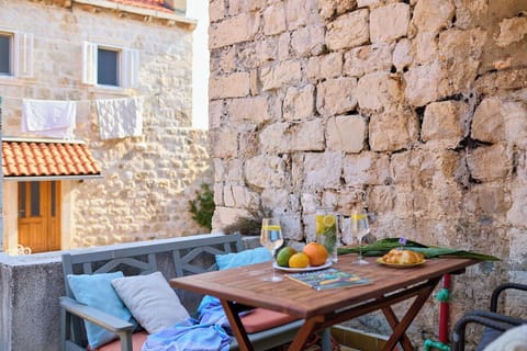 Enjoy a quiet moment on your private terrace, a charming space set against the historic stone walls of Dubrovnik's Old Town.