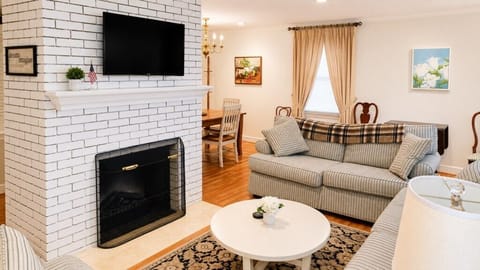 Comfortable living room with fireplace, TV and adjoining dining area.