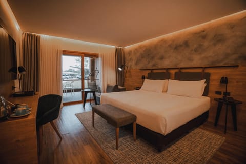 Unwind in a warm, modern bedroom with balcony access.