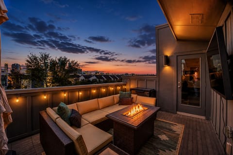 Cozy rooftop lounge with fire table and stunning sunset city views