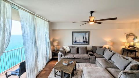 NEW Down sectional sofa anchors the living room with ceramic tile flooring, charming decor, and sheer curtains framing expansive Gulf views.